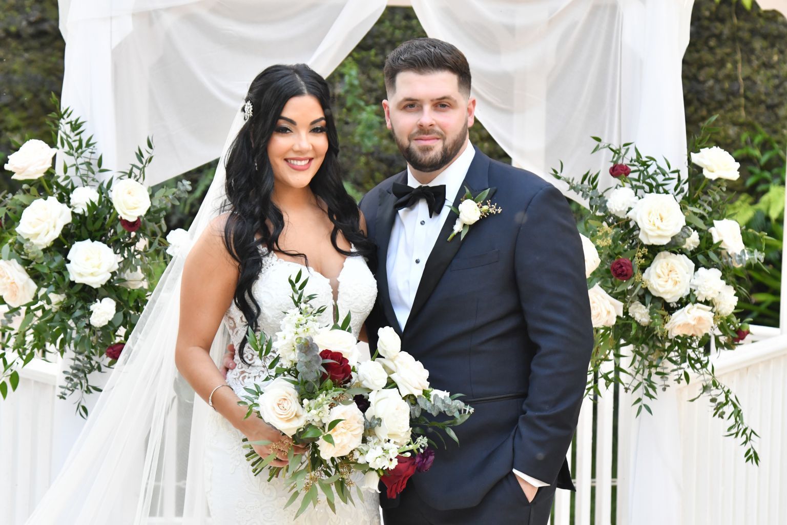 Wedding portrait under the floral ceremony gazebo