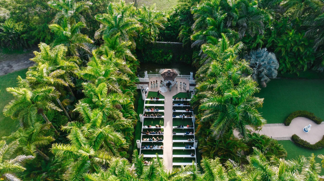 Real aerial photograph of Loveland Venue's outdoor wedding ceremony surrounded by tropical palms
